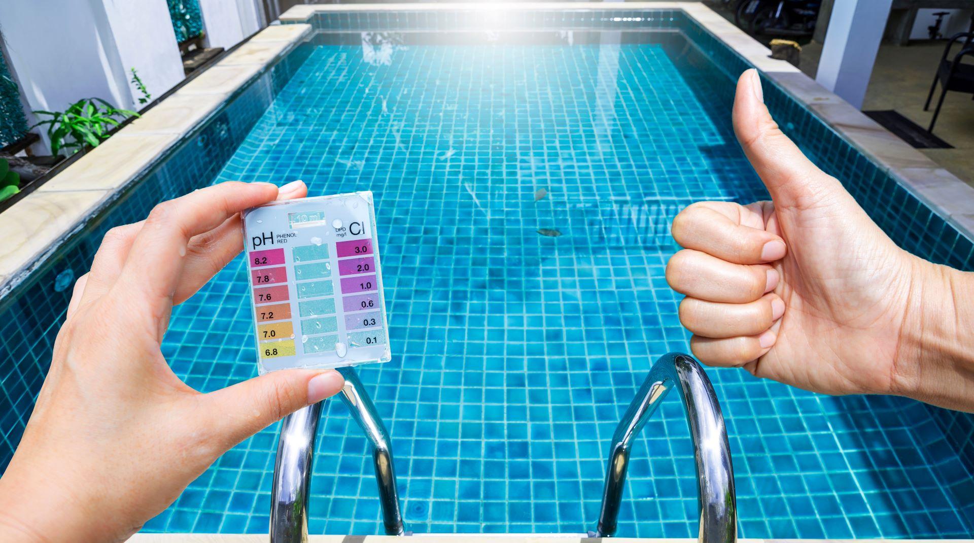 Hand über klarem Schwimmbadwasser, beste Wasserqualität, Poolpflege, gute Qualität Wassertest, Testkit für Schwimmbad